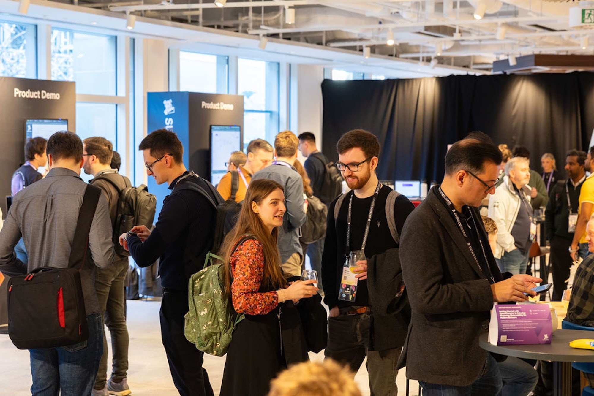Small groups of attendees chat with each other near the area for product demos.