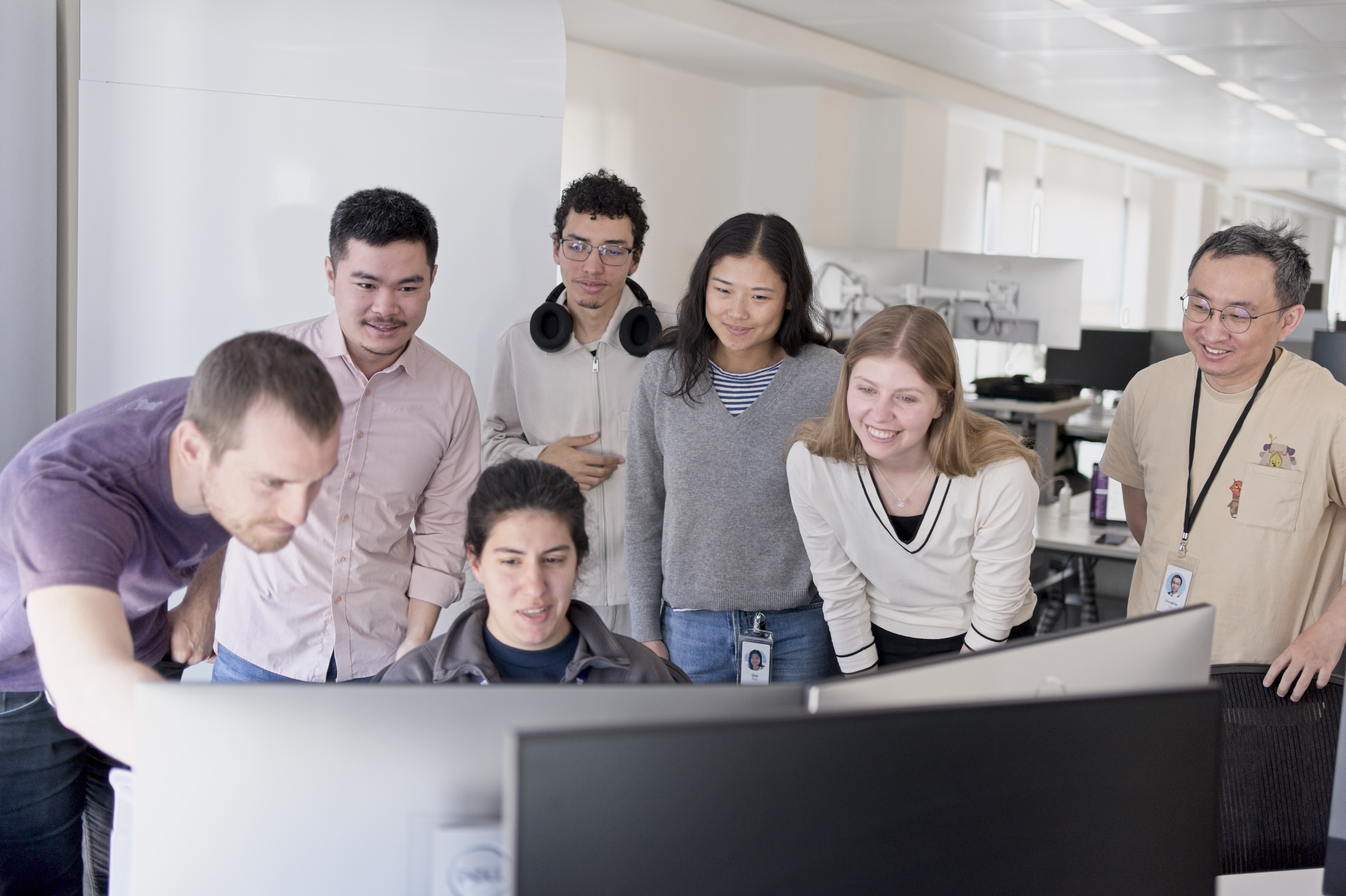 Members of the Datadog AI Research Lab review research together at a workstation in the Paris office.