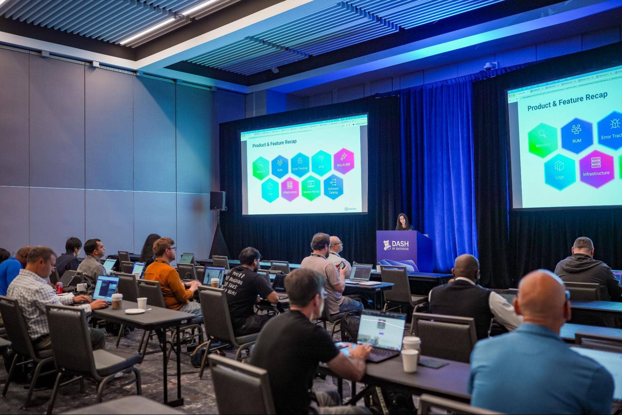 A speaker presenting a product and feature recap during a DASH workshop.