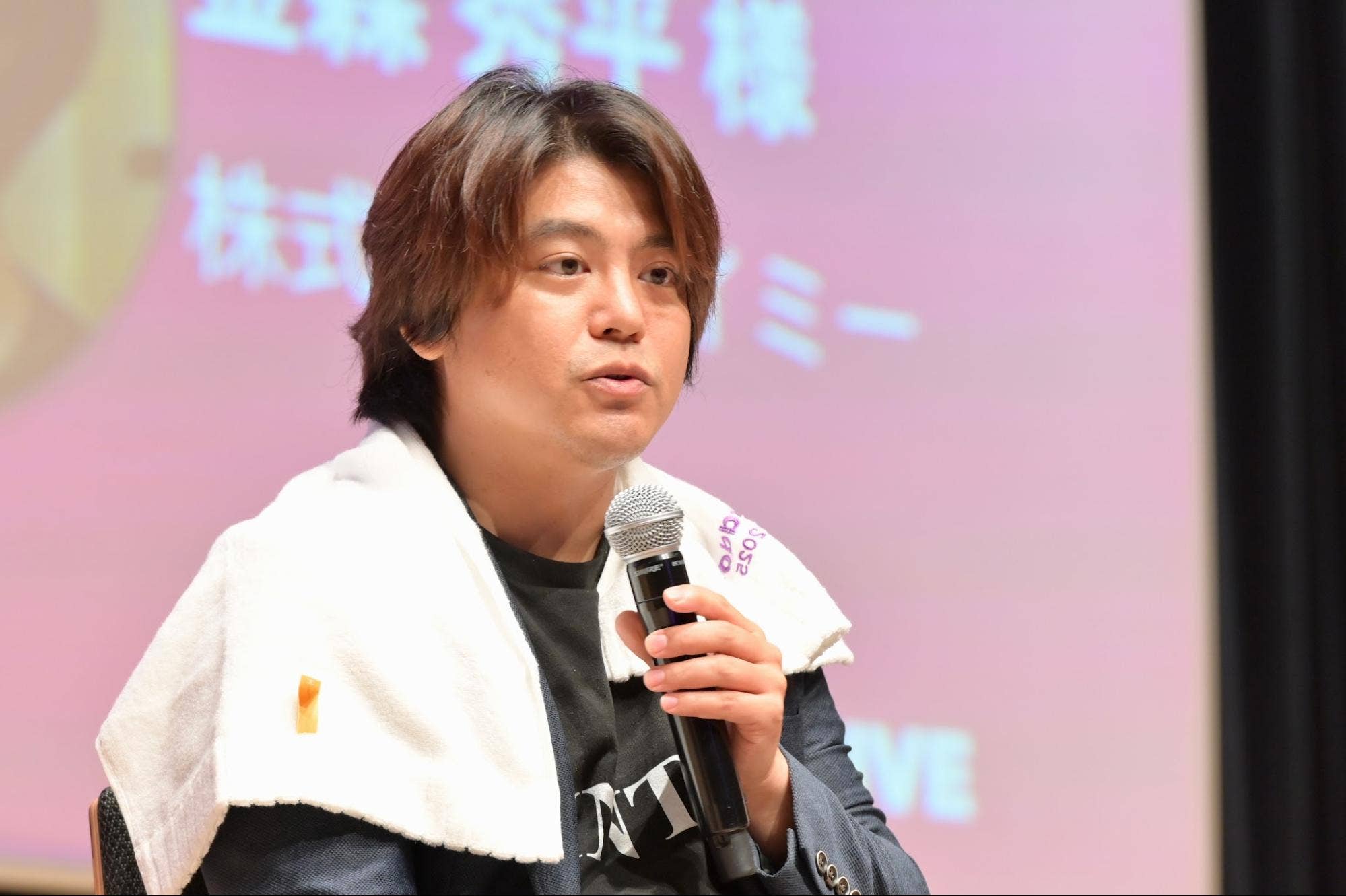 パネルディスカッションでハンドマイクを持って話すMNTSQ株式会社の藤原涼馬。