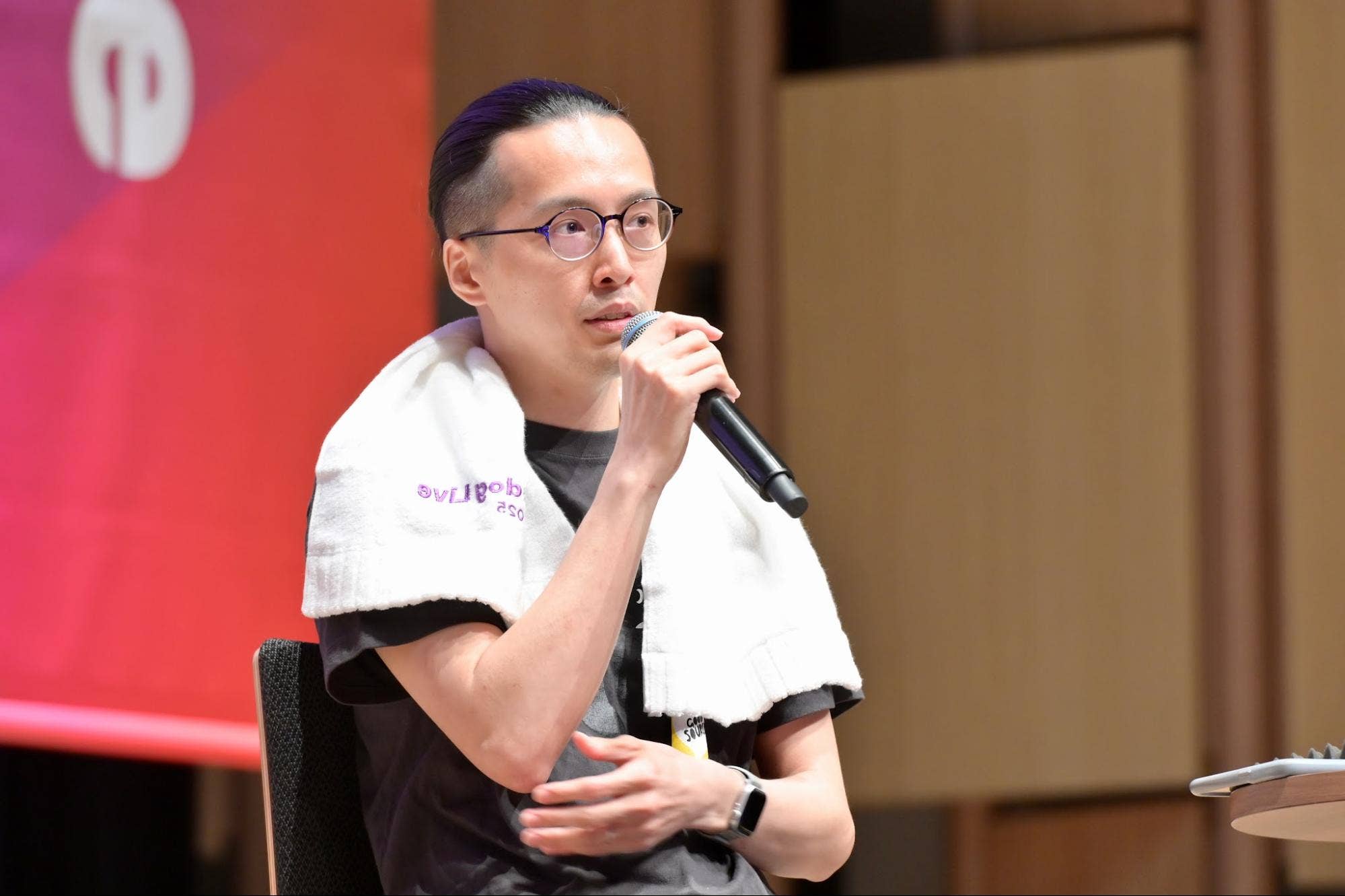 パネルディスカッションでハンドマイクを持って話す株式会社ヌーラボの吉岩祐貴。