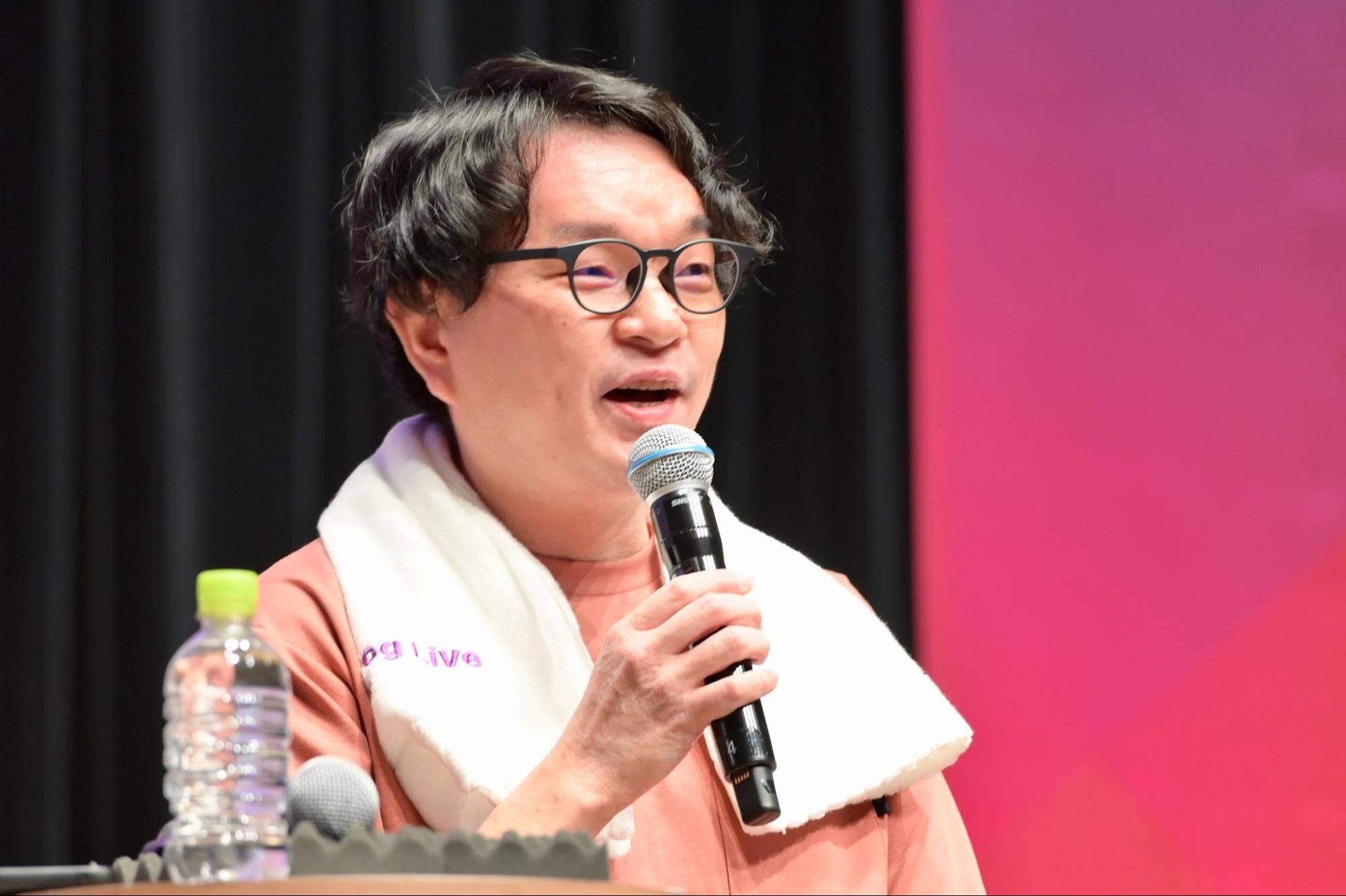 パネルディスカッションでハンドマイクを持って話す株式会社ジンズの大間俊樹。