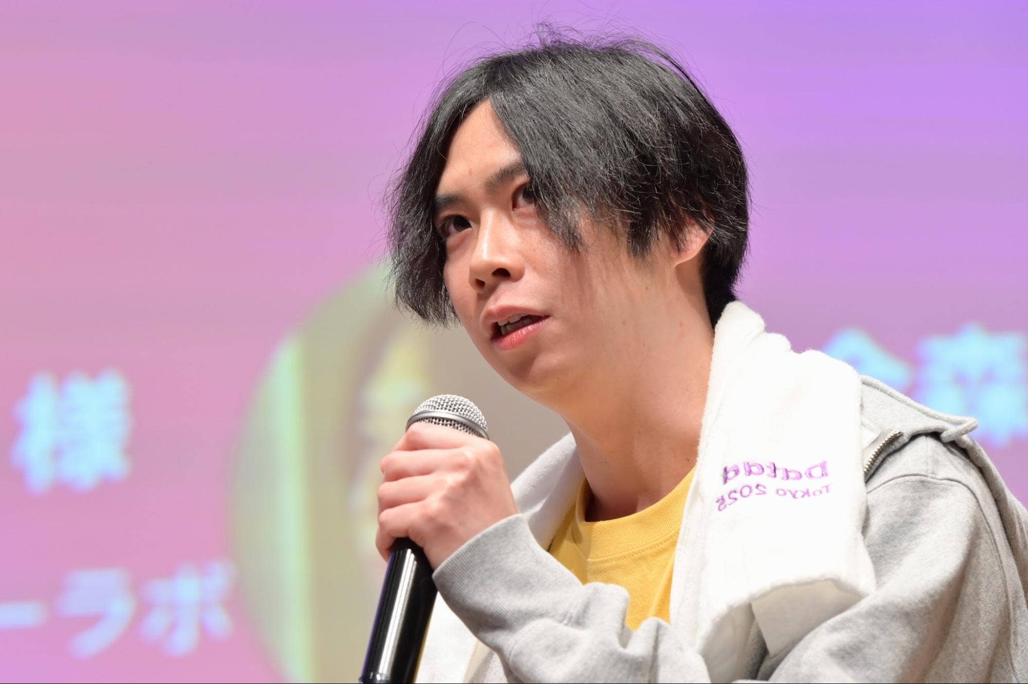 パネルディスカッションでハンドマイクを持って話す株式会社タイミーの金森秀平。