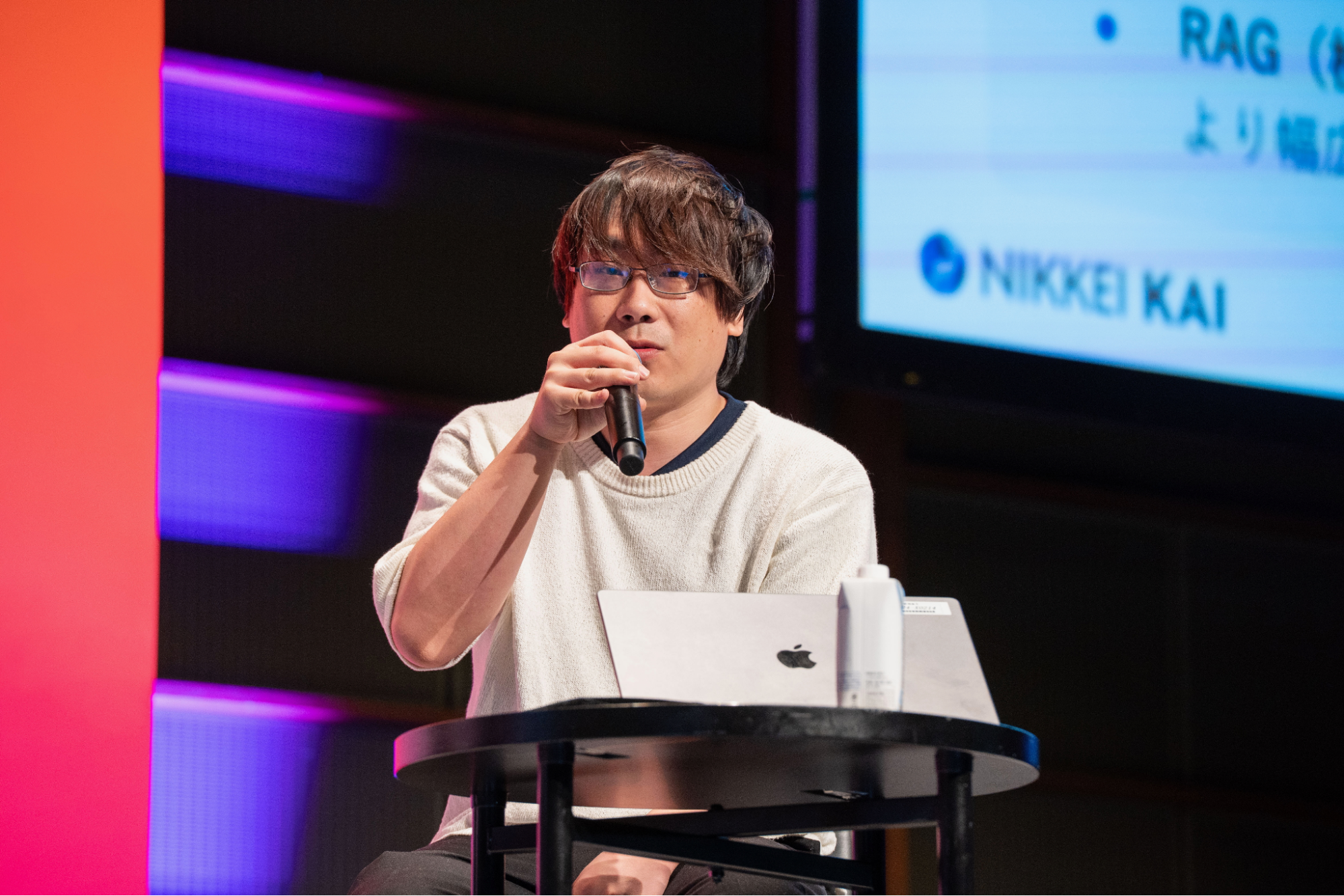 ステージ上でマイクを持って話す日本経済新聞社の若原義隆。