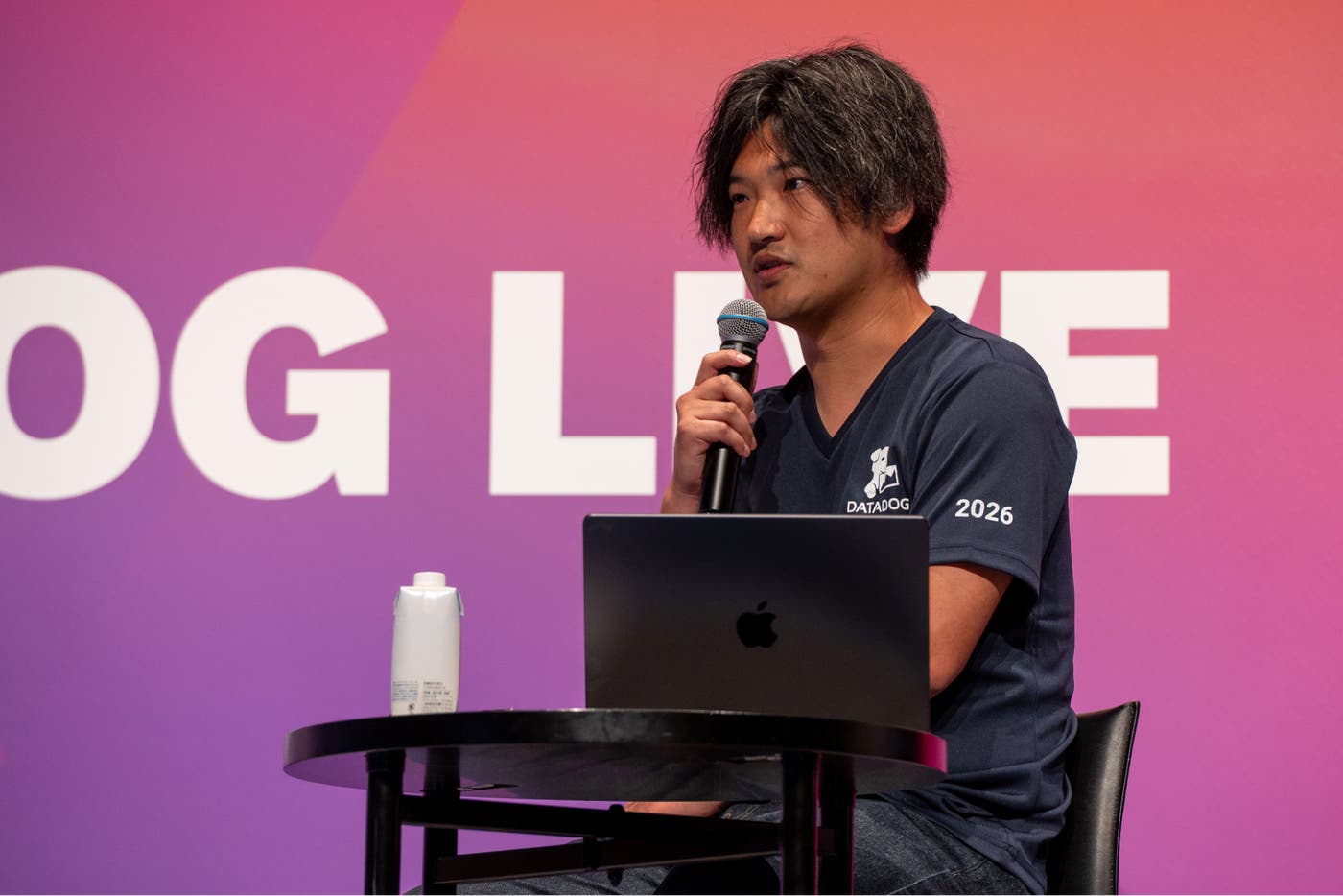 ステージ上でマイクを持って話す LegalOn Technologies の石垣雅基。 ステージ上でマイクを持って話す LegalOn Technologies の石垣雅基。